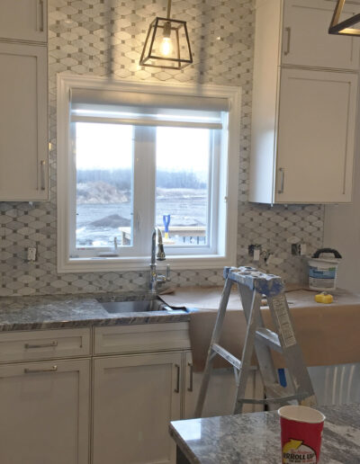 marble tile backsplash being installed in kitchen